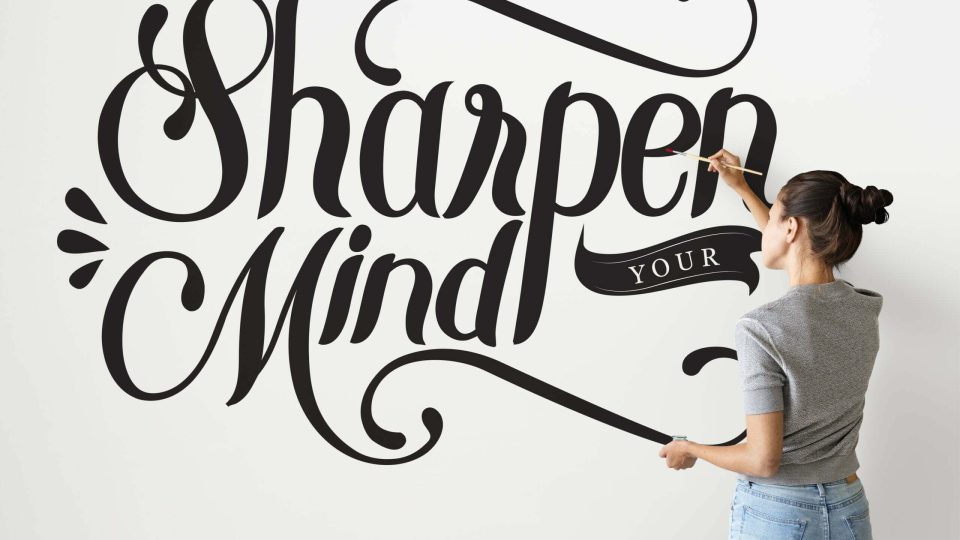 Female artist writing sharpen your mind quote on the wall